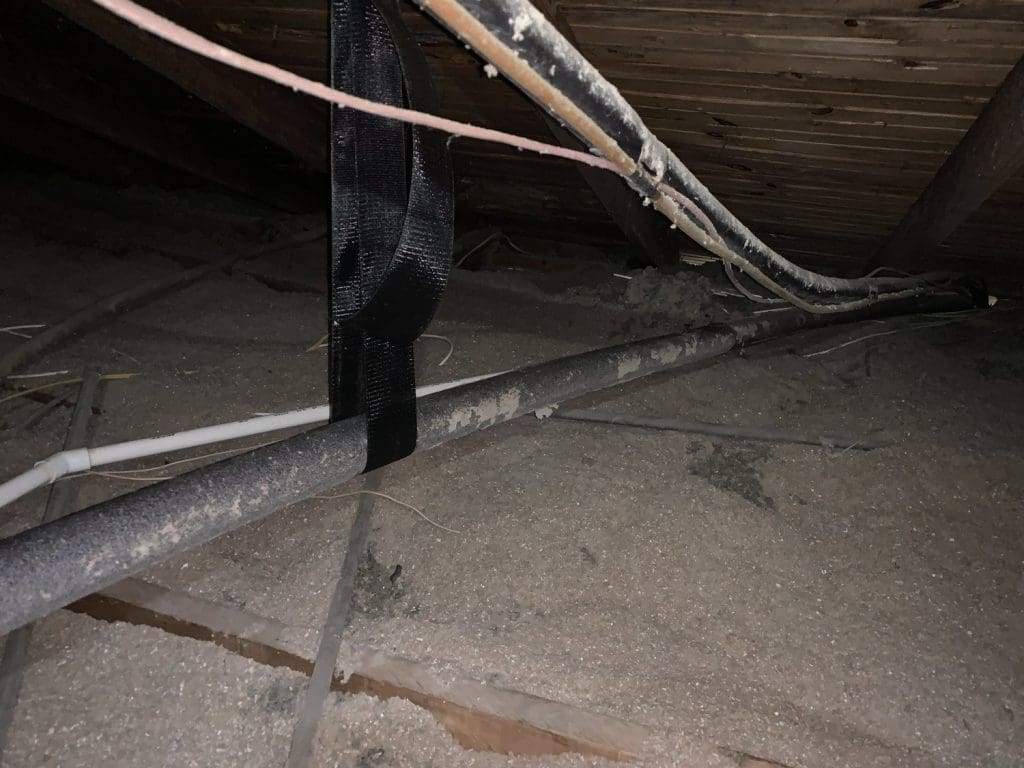 Refrigerant line set and wiring running across an attic floor