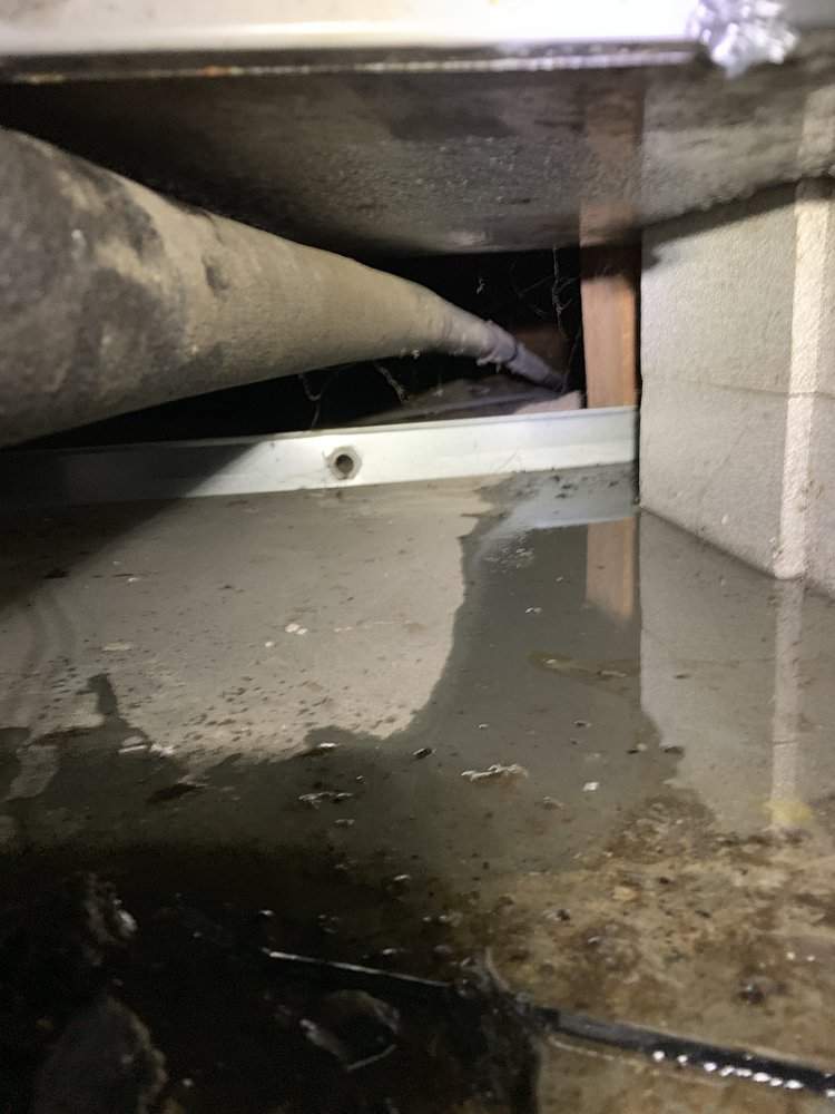 Standing water in a crawl space beneath ductwork