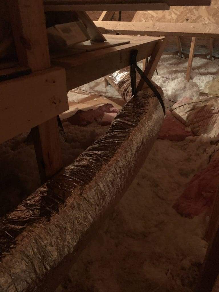 Insulated flex duct running across attic insulation