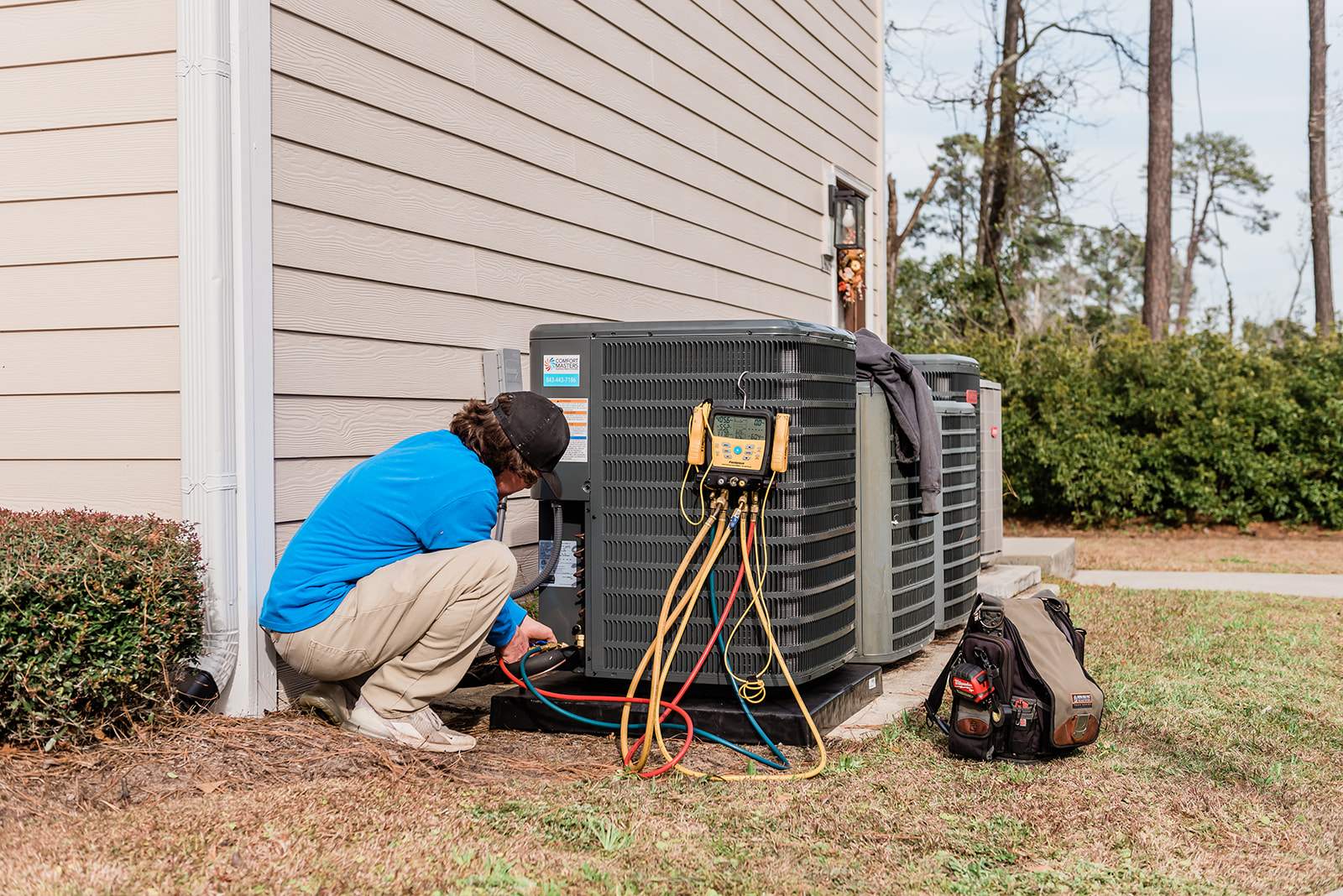 cody works on air conditioning unit