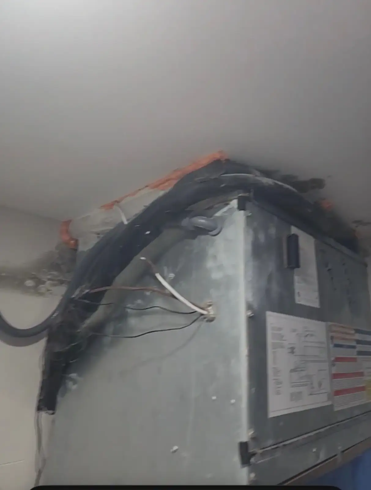 Loose low-voltage wiring and moisture staining under an air handler